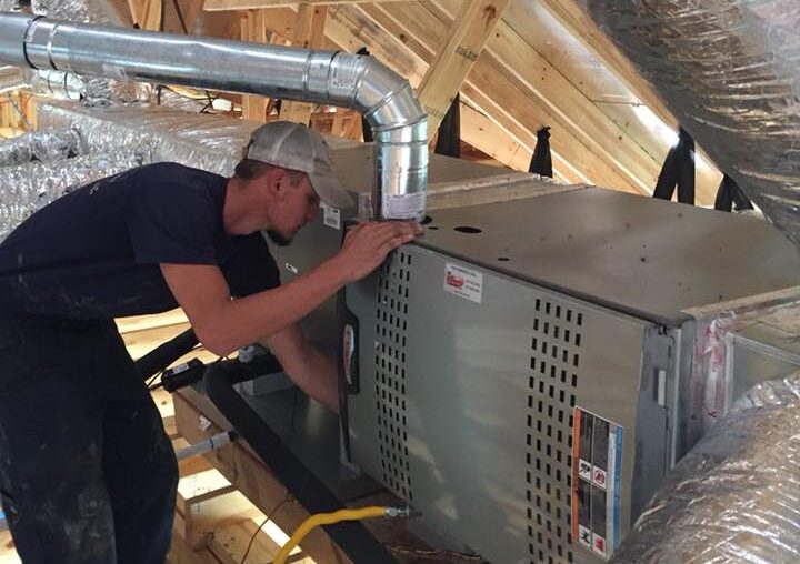 hvac technician performing ac maintenance in a home attic