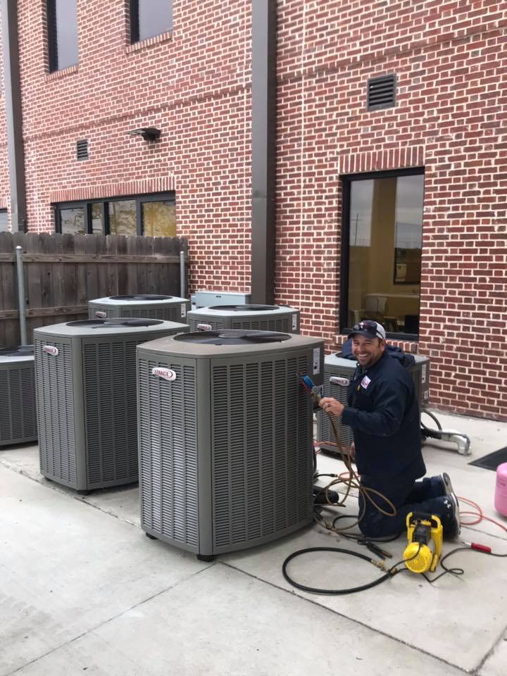 technician performing ac maintenance on an outdoor unit